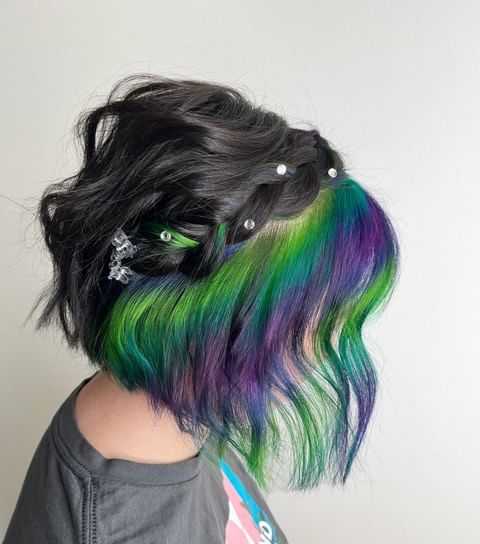 Woman with colorful rainbow hair and decorative hair clips.